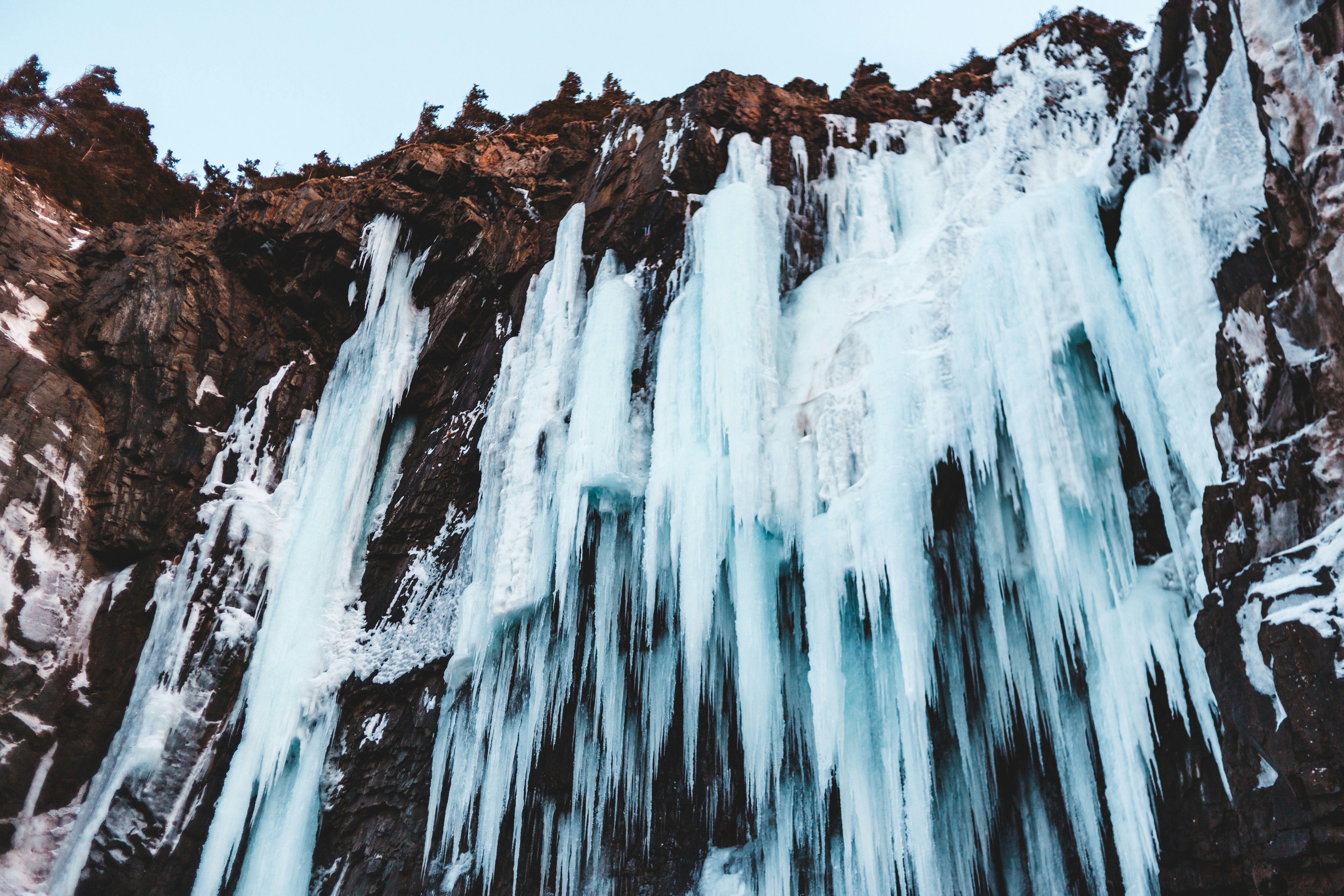 water falls on brown rocky mountain during daytime